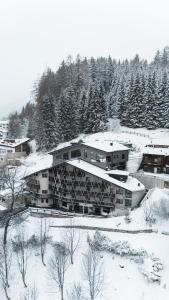 un edificio cubierto de nieve con árboles en el fondo en Arpuria l hidden luxury mountain home - ADULTS FRIENDLY, en Sankt Anton am Arlberg