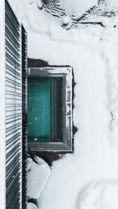 un edificio con una puerta verde en la nieve en Arpuria l hidden luxury mountain home - ADULTS FRIENDLY, en Sankt Anton am Arlberg