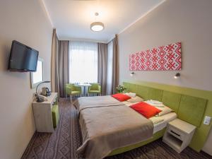 una camera d'albergo con letto e TV di Hotel *** NAT Krynica Zdrój a Krynica-Zdrój