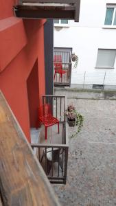 dos sillas rojas y una mesa en el lateral de un edificio en B&B Corte Rossa, en Tirano