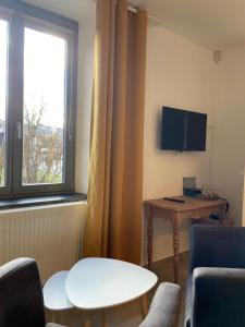 a living room with a table and a tv at Il était une fois in Herbeumont