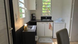 a small kitchen with a candle on a counter at Evasion Authentique en Tiny House - 1 Champagne OFFERT - Le Paradis des Petits Voyageurs in Le Diamant