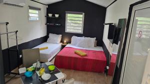 a small room with two beds and a table at Evasion Authentique en Tiny House - 1 Champagne OFFERT - Le Paradis des Petits Voyageurs in Le Diamant