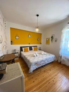 a bedroom with a large bed and a yellow wall at Takis Family Corfu in Kontokali