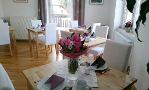 un comedor con una mesa con un jarrón de flores en Landhaus Semmering, en Semmering