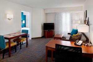 Residence Inn Saint Louis Airport / Earth City في مدينة ايرث: غرفة في الفندق مع طاولة طعام وغرفة معيشة