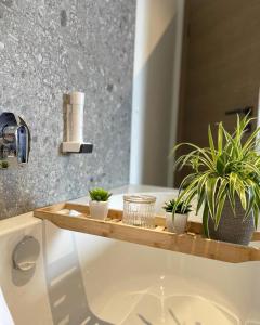 a bathroom with plants on a wooden tray on a tub at Freiraum 9 Living Apartment in Sankt Johann im Pongau