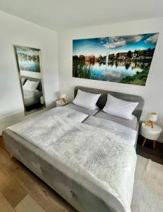 een slaapkamer met een groot bed en een schilderij aan de muur bij Seeblickapp. „Eure Auszeit“ in Goslar