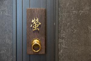 une porte en bois avec une porte en or percée dans l'établissement 奈良旅館別館 Sweet 螢 源, à Nara