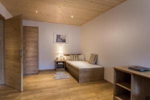 ein kleines Schlafzimmer mit einem Bett und einem Schreibtisch in der Unterkunft Appartements Lilly Rose in Zell am Ziller