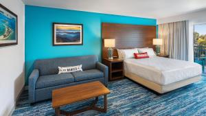 een hotelkamer met een bed en een bank bij Compass by Margaritaville Hotel Pigeon Forge in Pigeon Forge