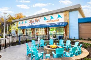 een patio met blauwe stoelen en een vuurplaats voor een restaurant bij Compass by Margaritaville Hotel Pigeon Forge in Pigeon Forge