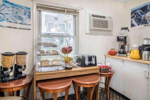 a kitchen with a counter with stools and a table with food at Rodeway Inn in Rutland