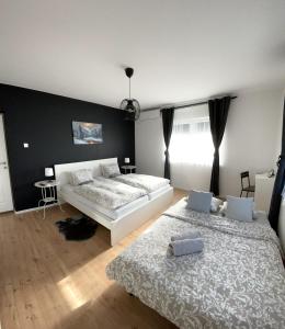 um quarto com 2 camas e uma parede preta em 4 STARS APARTMENTS Near Airport em Velika Gorica