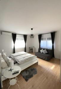 um quarto com uma cama, uma mesa e um sofá em 4 STARS APARTMENTS Near Airport em Velika Gorica