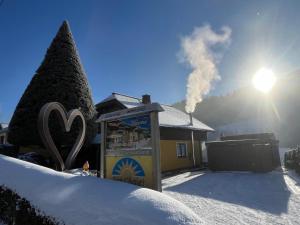 a sign in the snow next to a house with smoke at Sun Chalet in Schladming