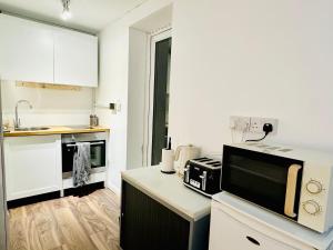 cocina con encimera y microondas en Stay in London - CENTRAL LONDON 30 minutes - WIMBLEDON 14 mins, en Londres