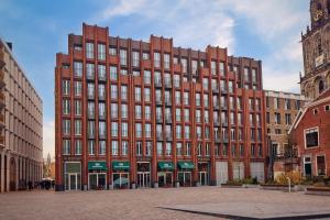 un gran edificio de ladrillo rojo en una ciudad en The Market Hotel, en Groninga