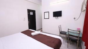 1 dormitorio con 1 cama, 1 silla y TV en The NoVo Agra, en Agra