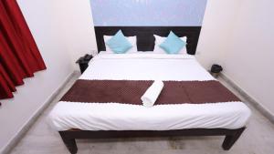 1 dormitorio con 1 cama grande con almohadas marrones y azules en The NoVo Agra, en Agra