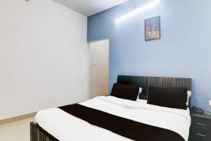 een slaapkamer met een bed met witte en blauwe muren bij Hotel O IIDM ECO CENTRE in Lucknow