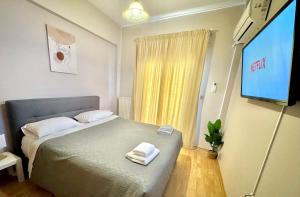 - une chambre avec un lit et une télévision à écran plat dans l'établissement George Airport Apartments, à Héraklion