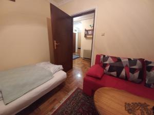 um pequeno quarto com uma cama e um sofá em Apartman Gala Beograd em Belgrado