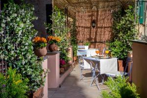 eine Terrasse mit Tischen, Stühlen und Pflanzen in der Unterkunft The Inn at the Roman Forum Luxury Collection - The Inn At The Roman Forum in Rom