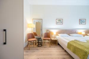 1 Schlafzimmer mit 2 Betten, einem Tisch und Stühlen in der Unterkunft Baross City Hotel - Budapest in Budapest