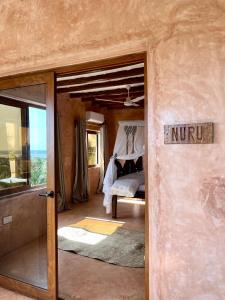 - une porte menant à une chambre avec un lit dans une pièce dans l'établissement Nuru Room at Lulu Beach, à Watamu