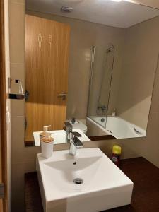 a bathroom with a white sink and a mirror at Ramona in Aveiro