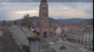 duży budynek z wieżą zegarową w mieście w obiekcie Plaisirs d'Alsace - Munster - Colmar - Route du vin w mieście Munster