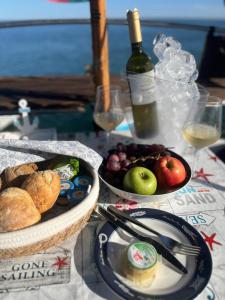 un tavolo con due ciotole di cibo e una bottiglia di vino di Houseboat - Faro in Ria Formosa a Faro