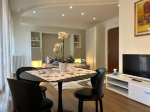 a living room with a table with chairs and a television at Valverde Apartment and Rooms in Verona