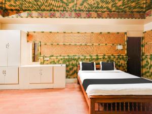 1 Schlafzimmer mit 2 Betten und einer Wand mit Mustern in der Unterkunft Super Hotel O Lawspet formerly Sejour De Comfort in Puducherry