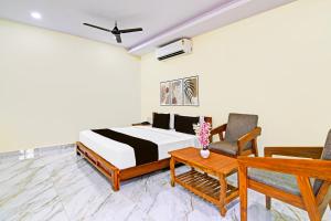 Super Townhouse Dwarakanagar Near Gurudwara في Raspari Palao: غرفة نوم بسرير وكرسي وطاولة