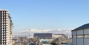 vistas a una ciudad con montañas en el fondo en Garnet Mir Hotel, en Tashkent