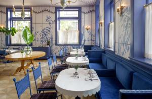 een restaurant met blauwe muren en tafels en stoelen bij Maison Metier, in the Unbound Collection by Hyatt in New Orleans