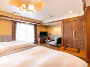 a hotel room with two beds and a television at Tabist Shizukuishi Resort Hotel in Shizukuishi