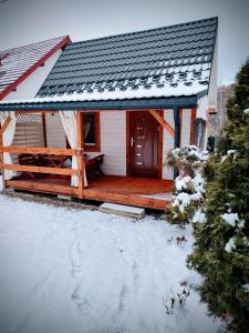 een huis met een houten terras in de sneeuw bij Domek Pocieszna Podkowa in Rabka-Zdroj