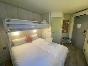 um quarto com uma cama branca e um beliche em Brit Hotel Chambery em Chambéry