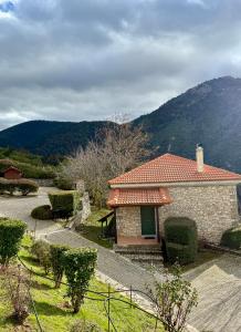 een klein gebouw met een berg op de achtergrond bij Villa Nano Kalavryta Βίλα στο βουνό με τζάκι κοντά στο χιονοδρομικό in Kalavrita