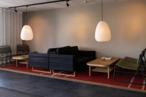 a waiting room with a couch and tables and lights at Strandnäs Hotell in Mariehamn