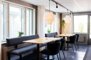 a restaurant with two tables and chairs and windows at Strandnäs Hotell in Mariehamn