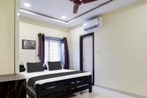 Schlafzimmer mit einem schwarzen und weißen Bett und einem Fenster in der Unterkunft Super Hotel O Murali Nagar Near NAD Junction in Visakhapatnam