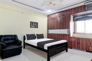 ein Schlafzimmer mit einem Bett und einem Stuhl in der Unterkunft Super Hotel O Murali Nagar Near NAD Junction in Visakhapatnam