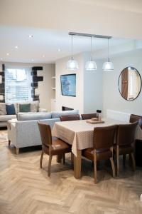 een woonkamer met een tafel en stoelen en een bank bij Snowdonia Quarryman cottage in Llanberis