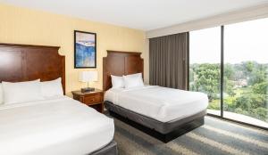 a hotel room with two beds and a large window at Embassy Suites by Hilton Bloomington/Minneapolis in Bloomington