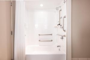 a bathroom with a white tub and a sink at Embassy Suites by Hilton Bloomington/Minneapolis in Bloomington