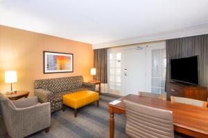 a living room with a couch a table and a television at Embassy Suites by Hilton Bloomington/Minneapolis in Bloomington